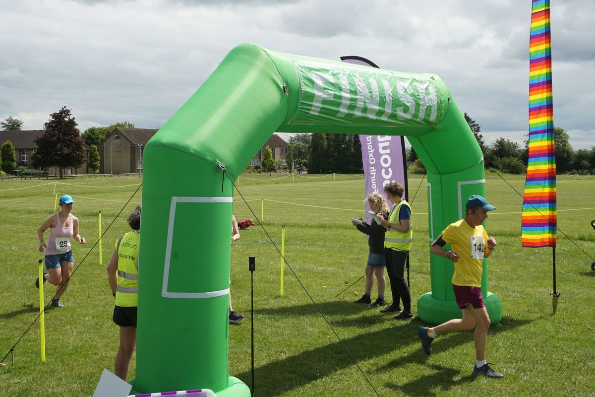 A runner in a yellow shirt coming through the finish arch